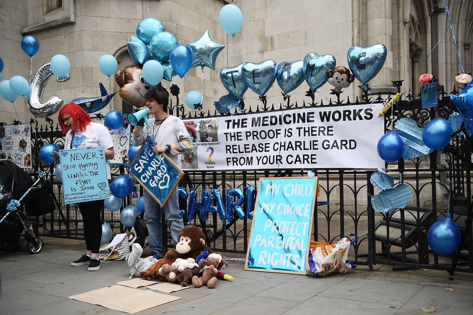 Fotografia protestujúcich ľudí s modrými balónmi a nápismi ako "vypustite Charlieho Gard z vašej starostlivosti"